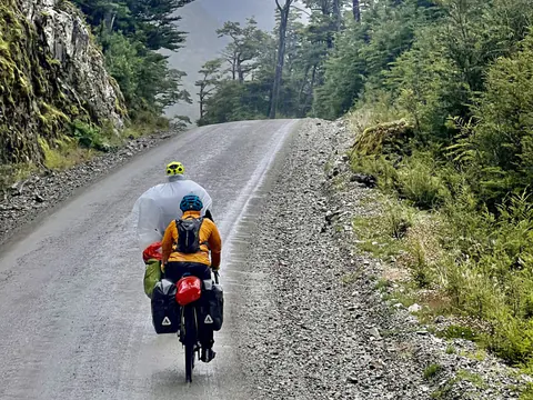 Ciclista con casco y alforjas en el ripio de la Carretera Austral